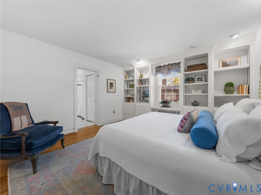 Hardwood flooring, built-in shelving, recessed lighting, and a white trim window