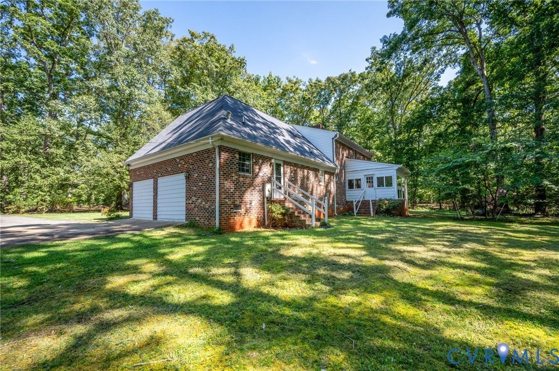 2409 Three Bridge Road, Rural, Powhatan, VA 23139 Brick exterior with a gabled roof and two white garage doors