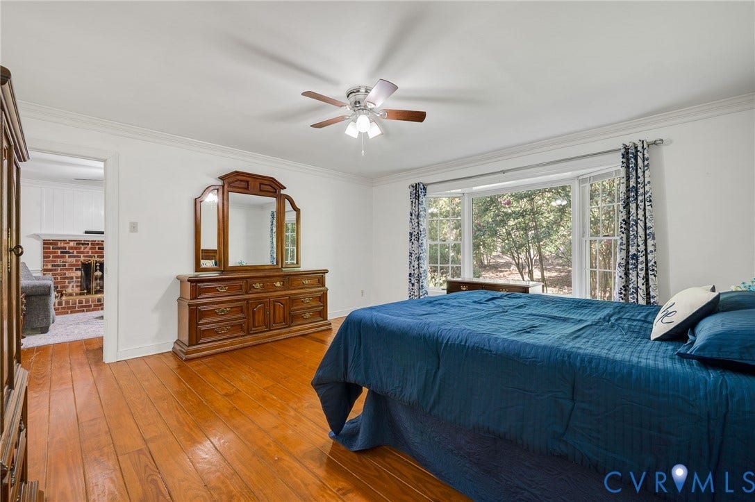 2409 Three Bridge Road, Rural, Powhatan, VA 23139 Hardwood flooring, ceiling fan, bay window, white crown molding, and a partial brick fireplace
