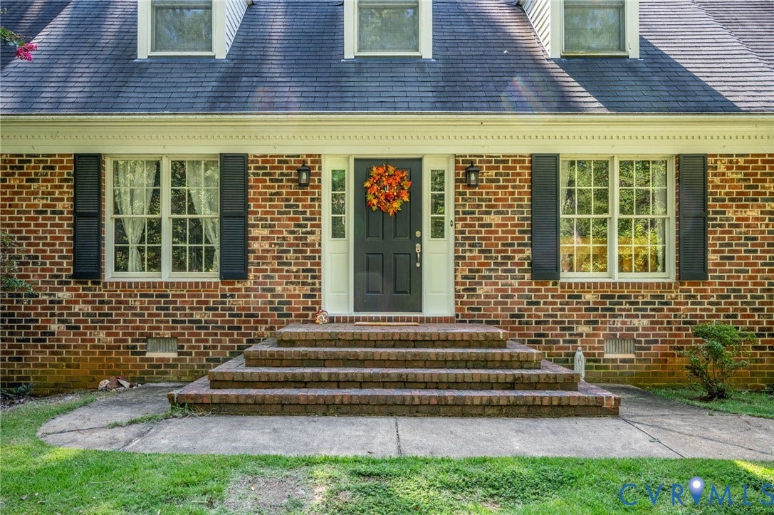 2409 Three Bridge Road, Rural, Powhatan, VA 23139 Brick facade featuring a dark shingle roof, white trim, and black shutters