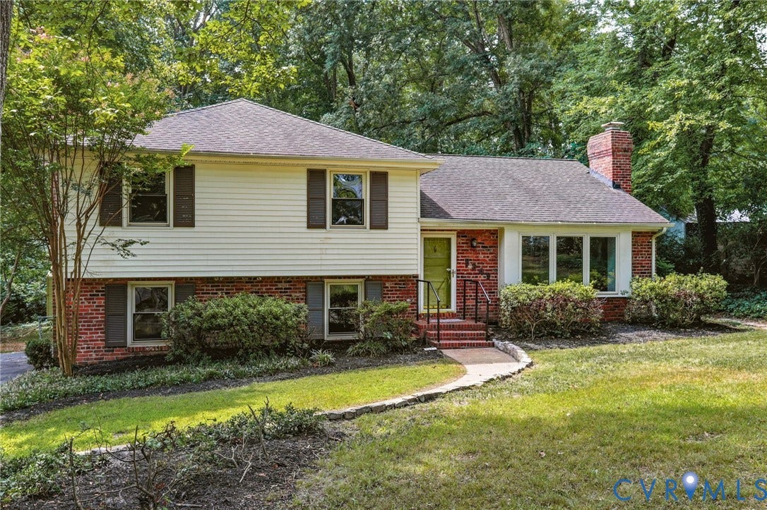 8349 Charlise Road, Oxford, Richmond, VA 23235 Traditional architecture featuring brick and siding facade, contrasting dark shutters, a prominent brick chimney, an inviting front entry with a vibrant green door, and mature landscaping