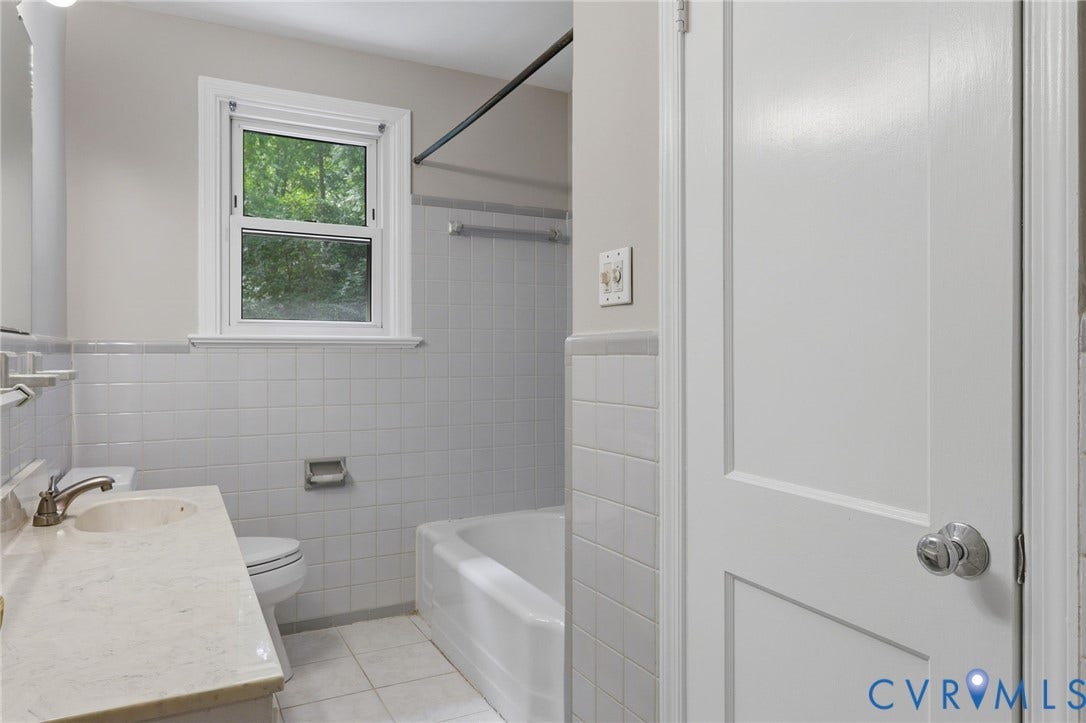 8349 Charlise Road, Oxford, Richmond, VA 23235 Bathroom featuring a built-in vanity with a single sink, an integrated bathtub, and white tiled walls