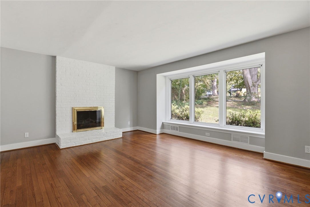 8349 Charlise Road, Oxford, Richmond, VA 23235 Hardwood flooring, painted brick fireplace with brass surround, and a three-panel bay window