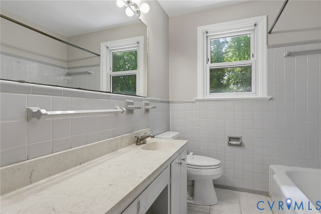 8349 Charlise Road, Oxford, Richmond, VA 23235 White tiled walls, single vanity with integrated sink, full-width mirror, and a window