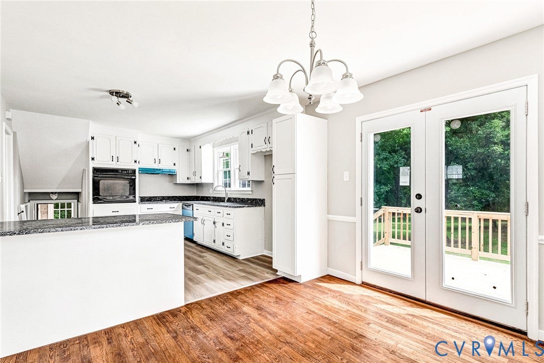 1605 CLOISTER Drive, Henrico, VA 23228 Wood-finish flooring, white cabinetry, built-in wall oven, a breakfast bar with stone-look countertop, and double glass-paneled doors leading to an exterior deck