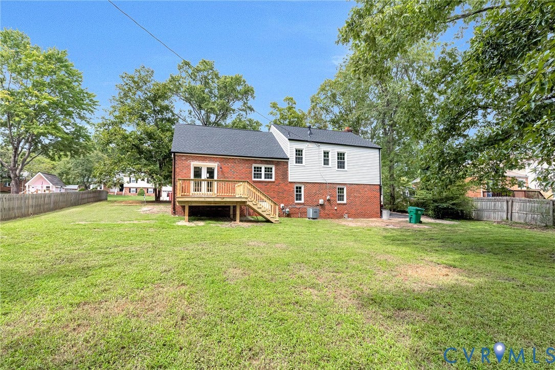 1605 CLOISTER Drive, Henrico, VA 23228 Expansive green lawn with a two-story brick and siding exterior, featuring a wood deck with stairs and a dark shingled roof