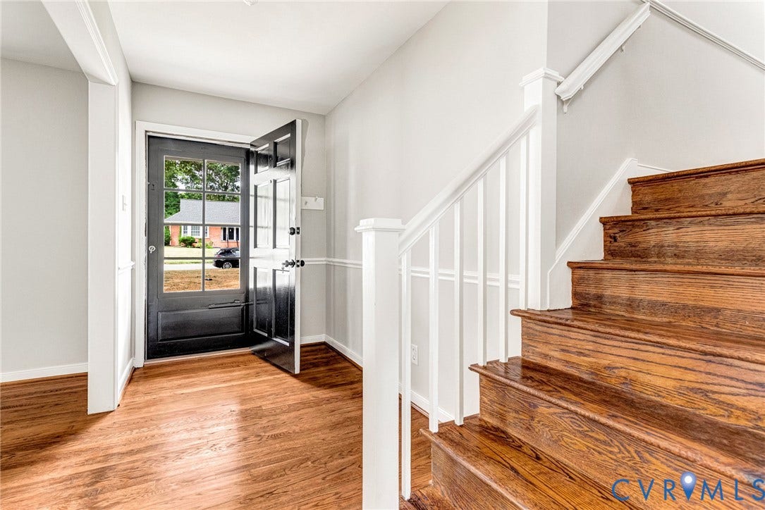 1605 CLOISTER Drive, Henrico, VA 23228 Wood-finish flooring, white painted walls, black paneled entry door with glass inserts, and wood stairs with white railings