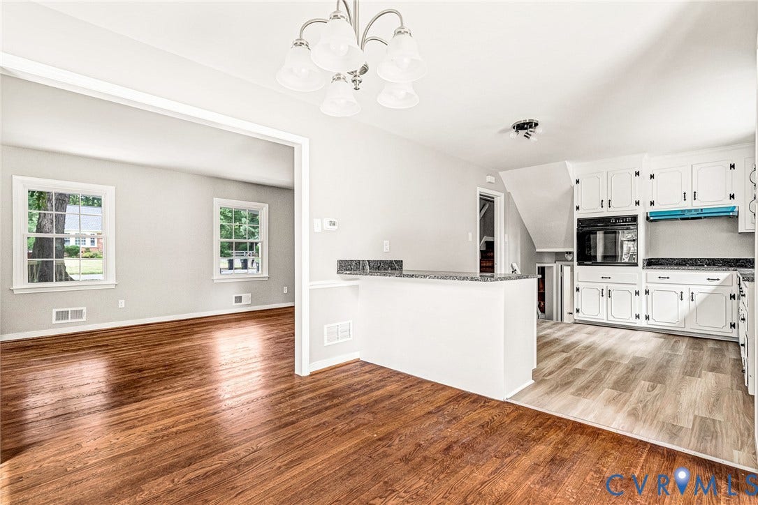 1605 CLOISTER Drive, Henrico, VA 23228 Wood-finish flooring throughout, white wall paint, white cabinetry with dark hardware, built-in oven, and light-toned flooring in the kitchen area