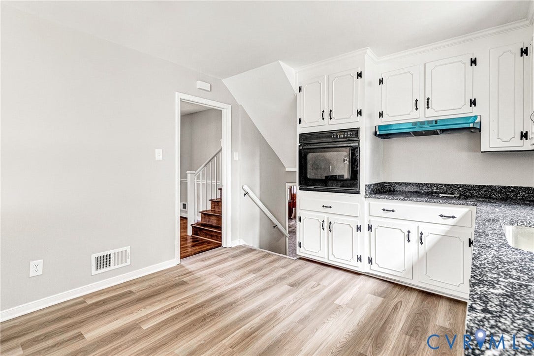 1605 CLOISTER Drive, Henrico, VA 23228 Wood-finish flooring, white cabinetry with black hardware, built-in oven, integrated microwave, and dark speckled countertops
