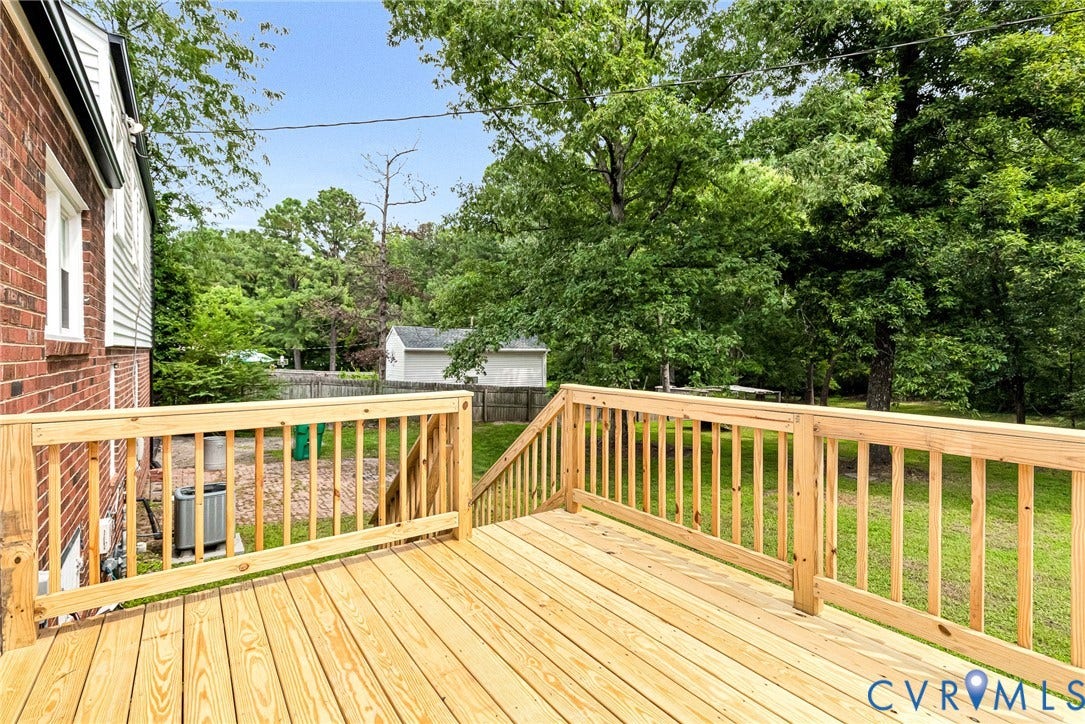 1605 CLOISTER Drive, Henrico, VA 23228 Expansive wood deck with natural wood railing, featuring a brick and siding exterior and mature trees