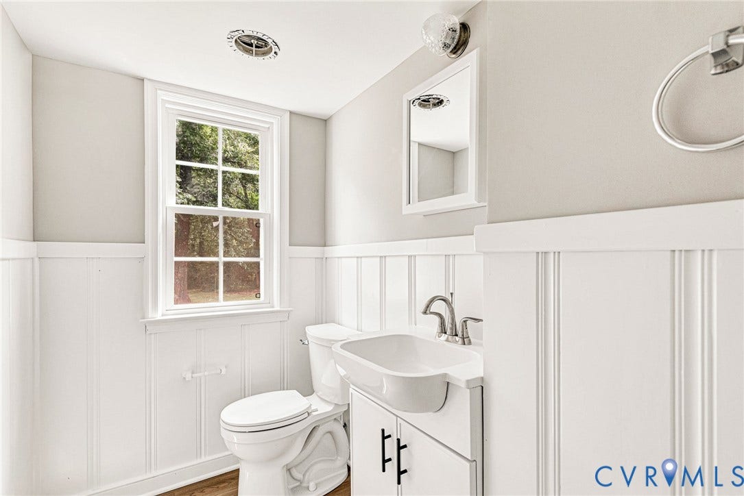 1605 CLOISTER Drive, Henrico, VA 23228 White wainscoting with upper wall paneling, a single-hung window, white vanity with integrated sink, and a chrome faucet