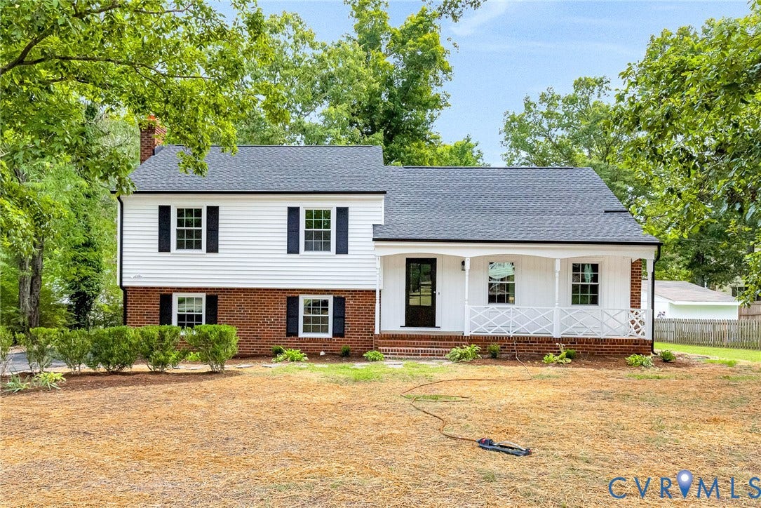 1605 CLOISTER Drive, Henrico, VA 23228 Two-story residence featuring white siding and brick facade, a covered porch with white railing, a dark entry door, and a dark shingle roof