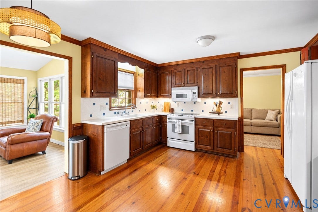 Kitchen featuring wood-finish flooring, wood cabinetry, white appliances, white countertops, and a tile backsplash