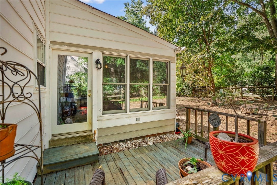 Exterior white siding, multi-pane windows, full-light door, and wood deck