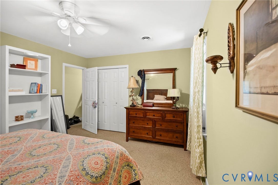 Integrated ceiling fan with light fixture, light green wall finishes, carpeted flooring, and white bi-fold closet doors