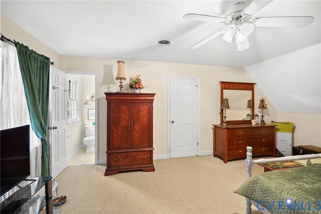 Carpeted flooring with a white ceiling fan and light fixture