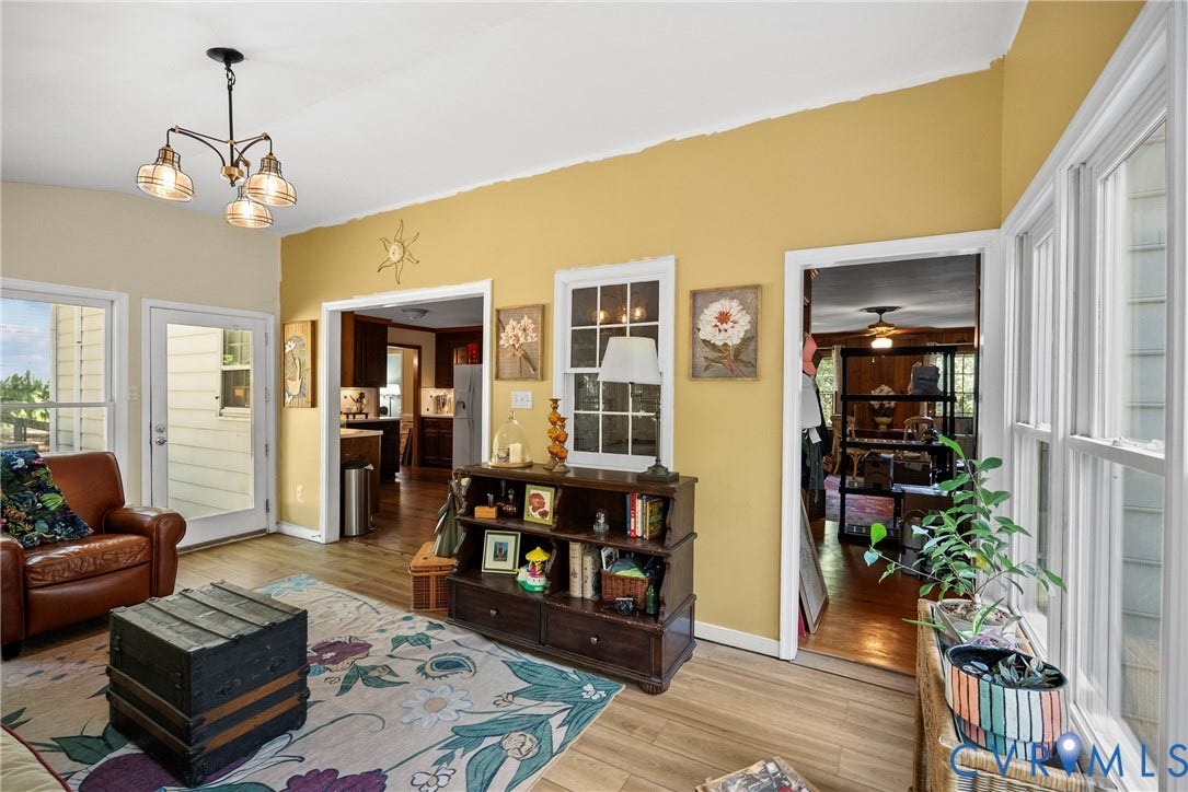 Recessed wall openings, light wood-finish flooring, and a multi-light ceiling fixture enhance this bright living area