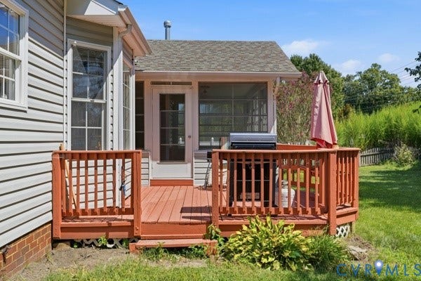 Wood-tone deck with lattice railing, white vinyl siding, and a screened-in porch with a glass-paneled door