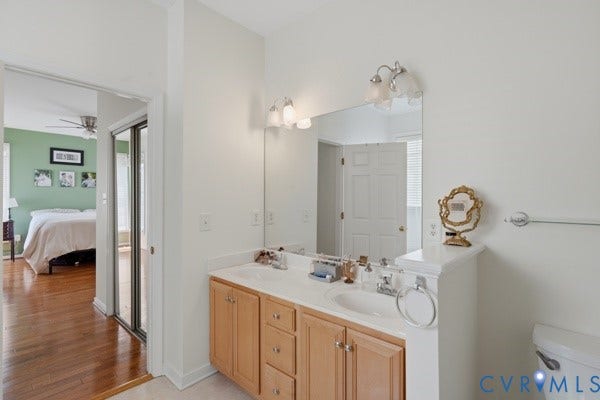 Dual vanity with a light wood-finish cabinet and two integrated sinks