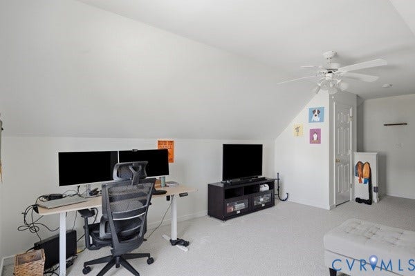 Sloped ceiling room featuring a white ceiling fan with light kit, white paneled door, and light-colored carpet