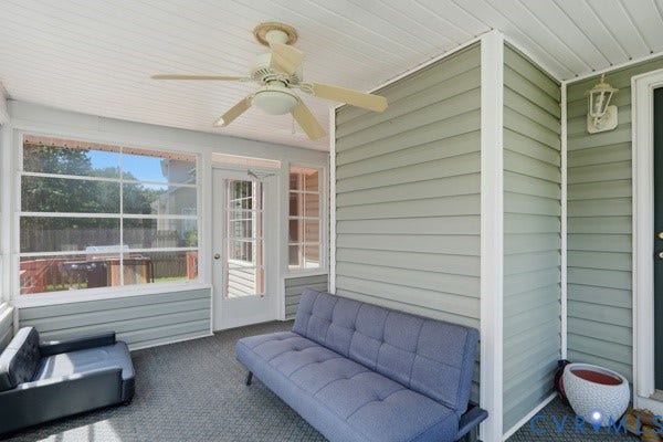 Screened porch featuring a ceiling fan, white paneled ceiling, multiple windows, a glass-paned door, and siding walls