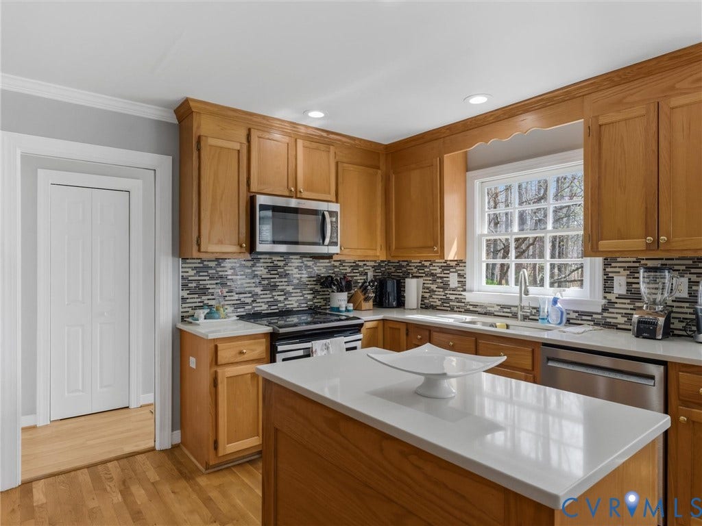 3489 Richards Run, Powhatan, VA 23139 Kitchen with wood cabinetry, stainless steel appliances, mosaic tile backsplash, and light-toned countertops