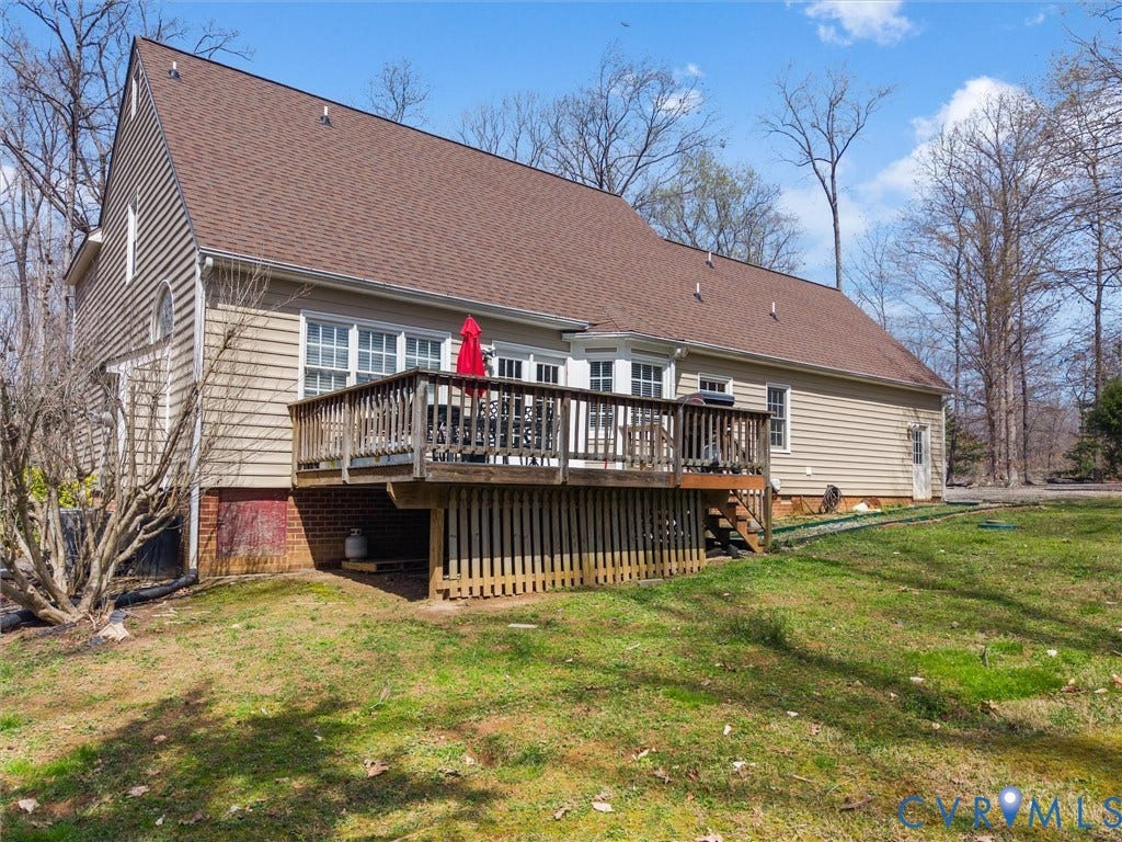 3489 Richards Run, Powhatan, VA 23139 Expansive rear deck with wooden railing and stairs, multiple windows, and a side door entry