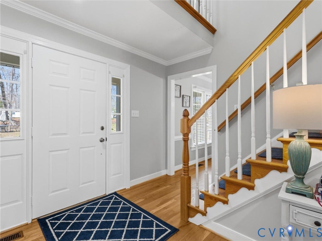 3489 Richards Run, Powhatan, VA 23139 Hardwood flooring, painted white trim, staircase with wood handrail, paneled entry door, and side light windows