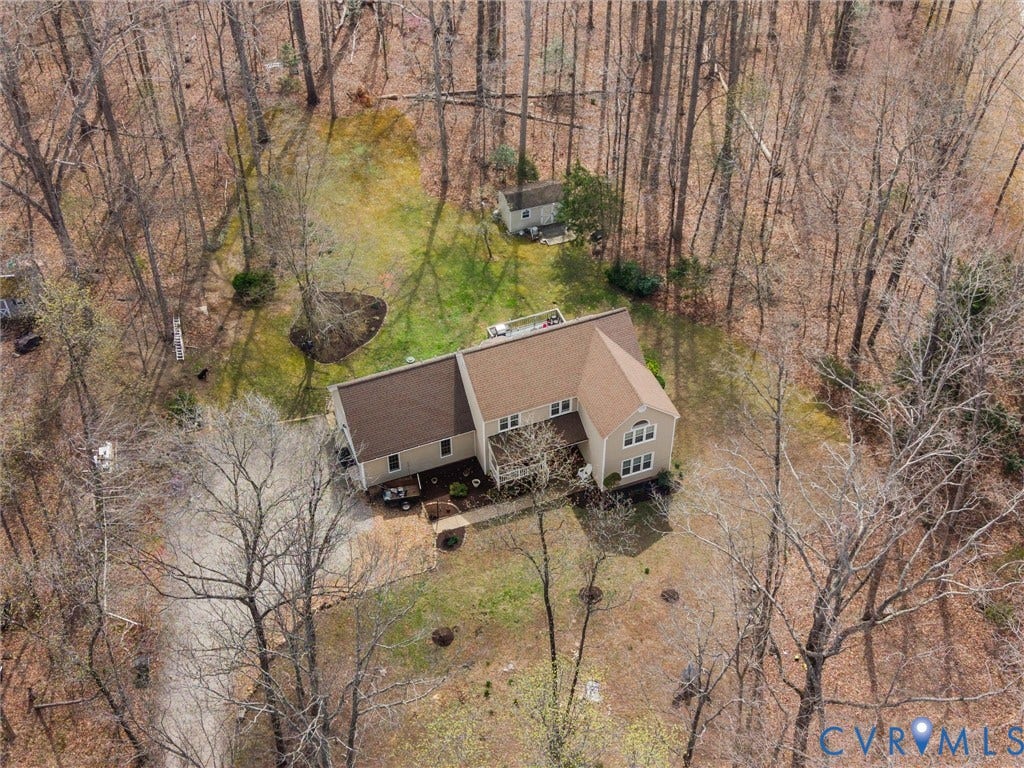 3489 Richards Run, Powhatan, VA 23139 Expansive wooded property featuring a two-story residence with a brown shingle roof, a detached shed, and a circular driveway