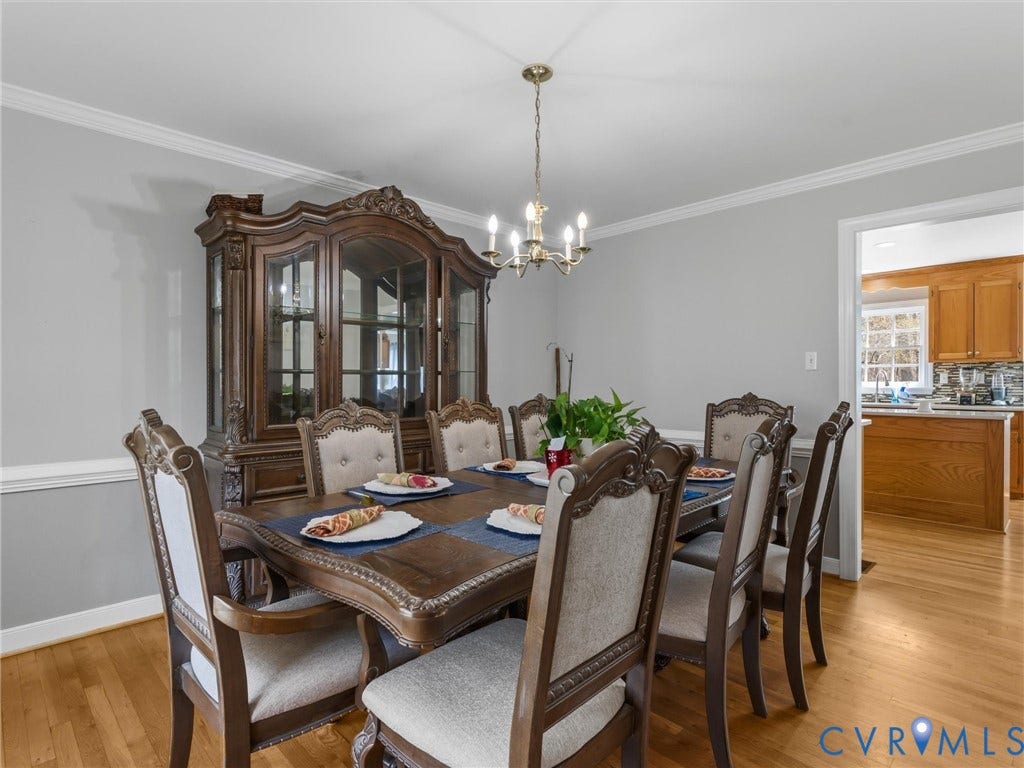 3489 Richards Run, Powhatan, VA 23139 Hardwood flooring, crown molding, and a chandelier illuminate this dining space