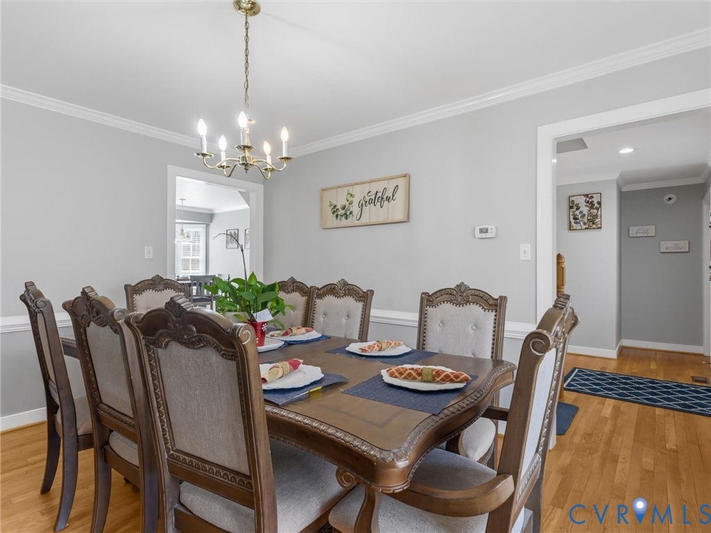 3489 Richards Run, Powhatan, VA 23139 Hardwood flooring, crown molding, chair rail molding, and a brass-finish chandelier