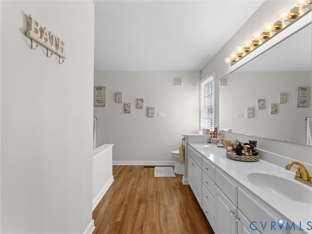 3489 Richards Run, Powhatan, VA 23139 Double vanity with white cabinetry, gold-tone fixtures, and a spacious countertop
