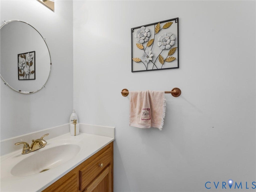 3489 Richards Run, Powhatan, VA 23139 Wood-finish vanity with a white countertop and undermount sink