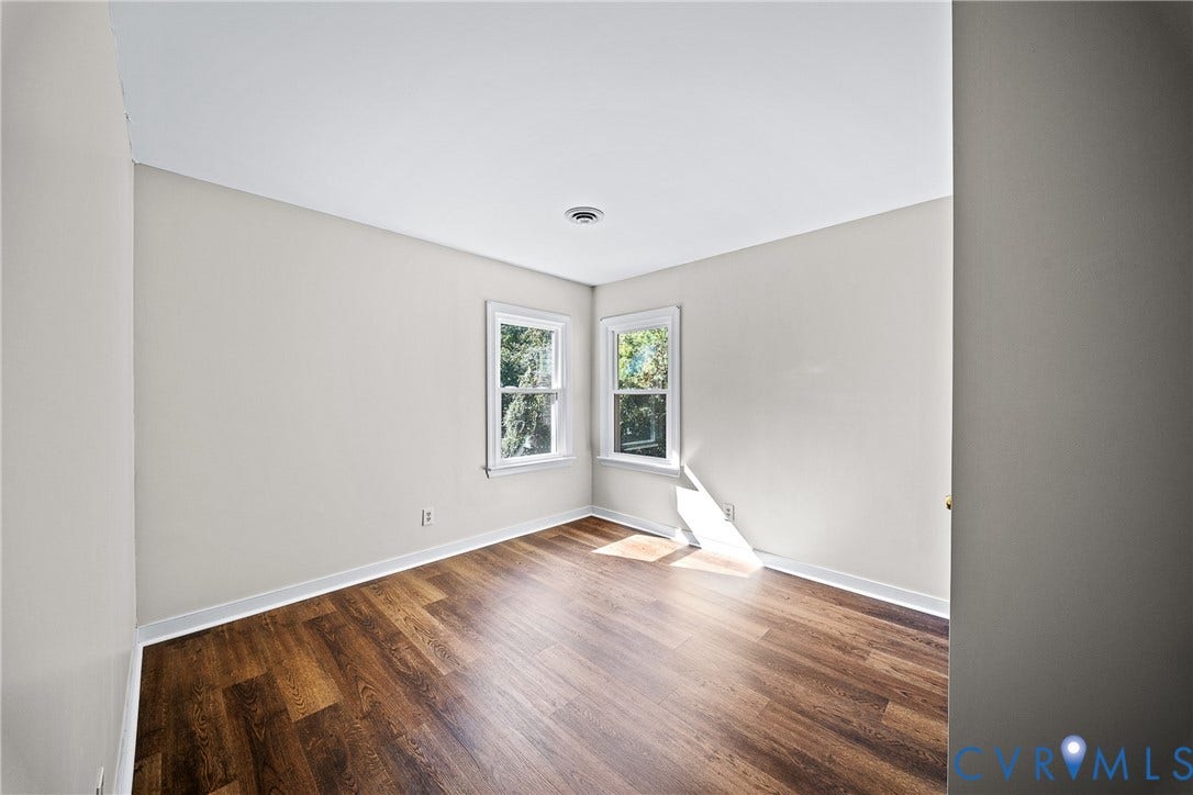 1608 Queens Point Drive, Henrico, VA 23238 Interior room featuring neutral wall paint, wood-finish flooring, and two double-hung windows with white casings