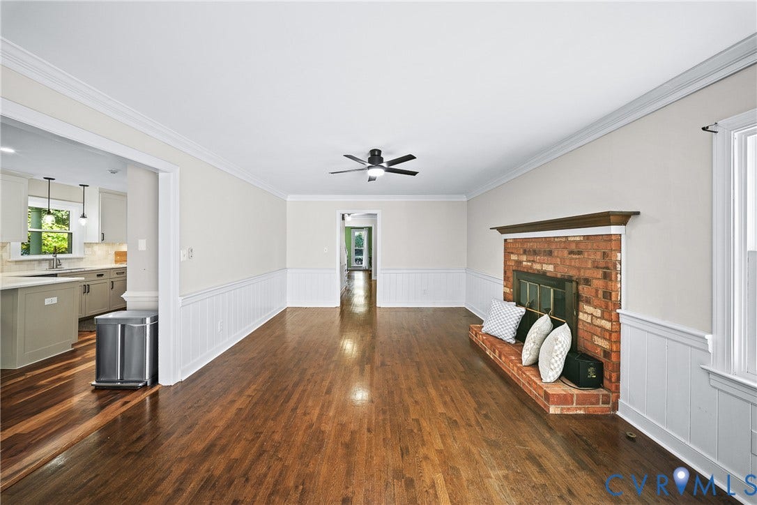 1608 Queens Point Drive, Henrico, VA 23238 Living area featuring wood-finish flooring, brick fireplace with a wood mantel, white wainscoting, and a ceiling-mounted light fixture with fan