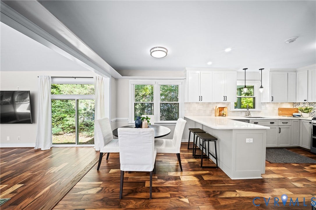 1608 Queens Point Drive, Henrico, VA 23238 Kitchen featuring white cabinetry, wood-finish flooring, a quartz-topped peninsula with bar seating, and sliding glass doors