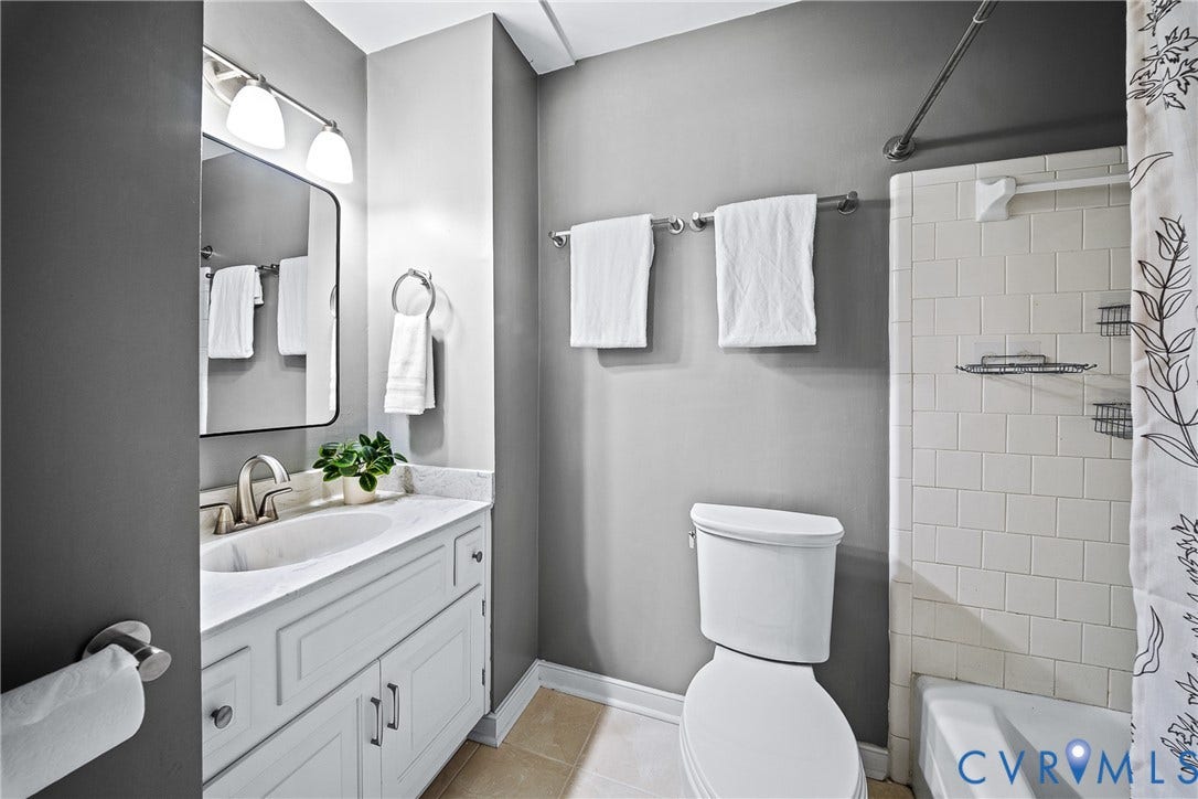 1608 Queens Point Drive, Henrico, VA 23238 Bathroom featuring a white vanity with stone-style countertop, integrated sink, chrome hardware, rectangular mirror, and tile-surround tub