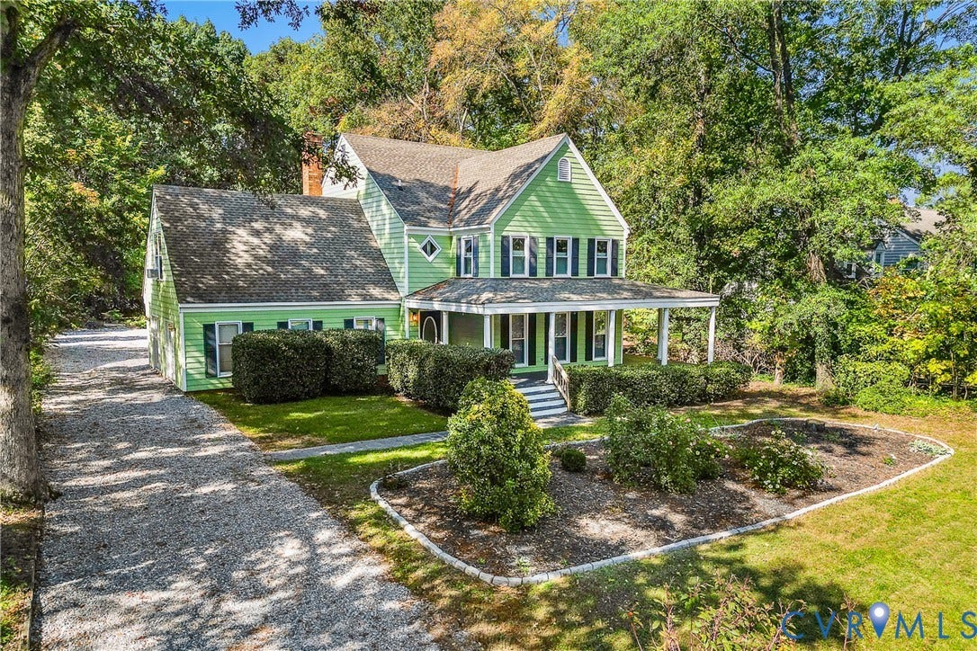 1608 Queens Point Drive, Henrico, VA 23238 Two-story home with light green horizontal lap siding, covered front porch, gravel driveway, and mature landscaping