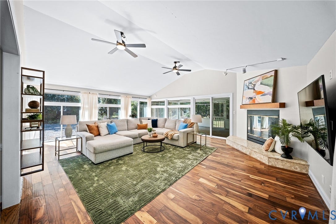 1608 Queens Point Drive, Henrico, VA 23238 Vaulted ceilings with dual ceiling fans, expansive floor-to-ceiling windows, wood-finish flooring, and a stone-hearth fireplace with a wood mantel