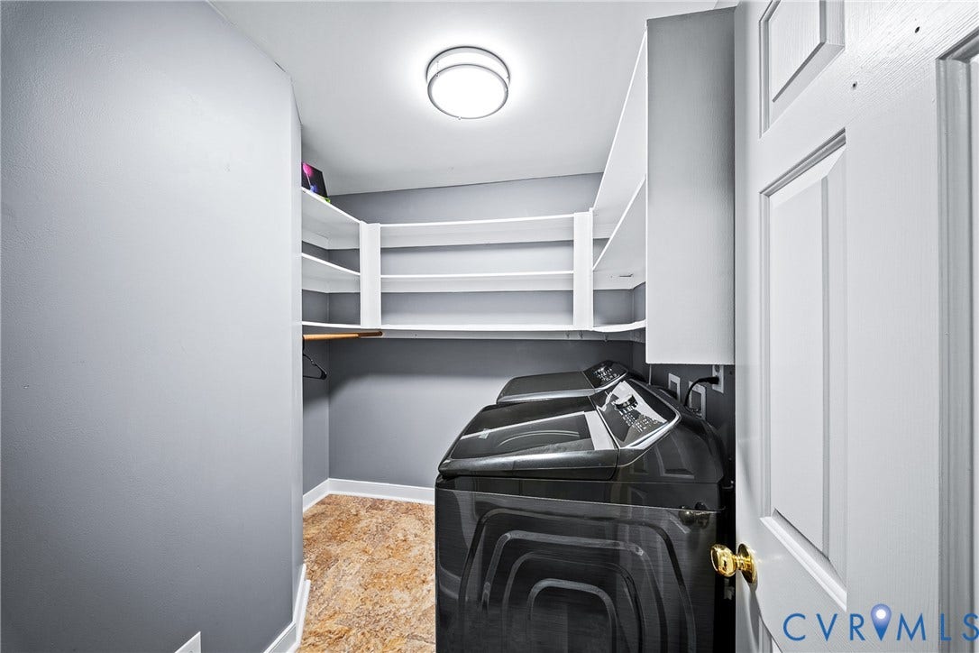 1608 Queens Point Drive, Henrico, VA 23238 Laundry space featuring multi-tiered white built-in shelving, flush-mount ceiling lighting, textured stone-pattern flooring, and a paneled door with brass-finish hardware