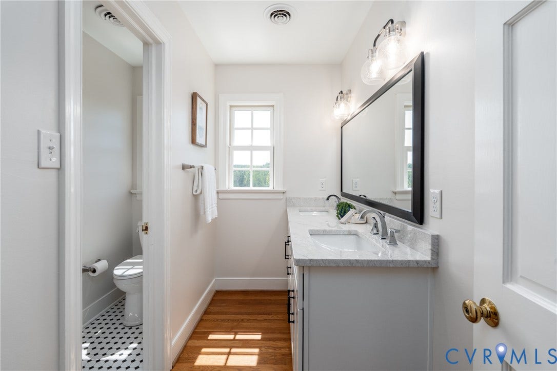 Dual vanity with a stone countertop, individual undermount sinks, and chrome-finish faucets