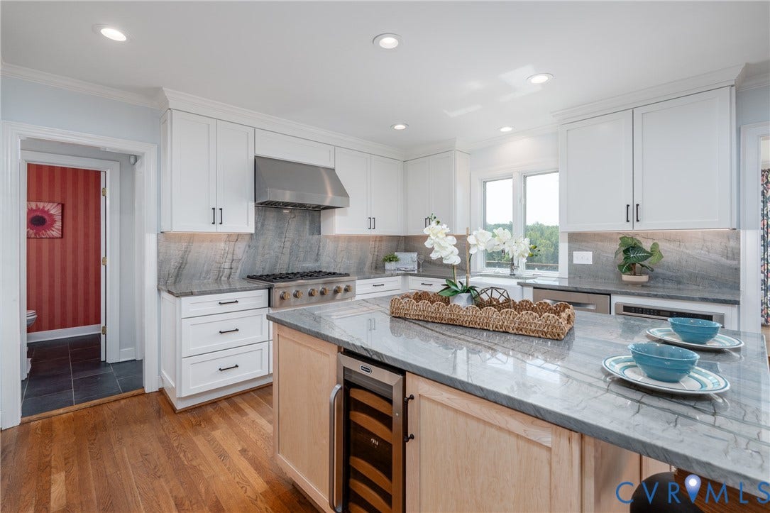 Kitchen featuring white cabinetry, stainless steel range hood, stone countertops with matching backsplash, wood-finish flooring, and an integrated beverage refrigerator