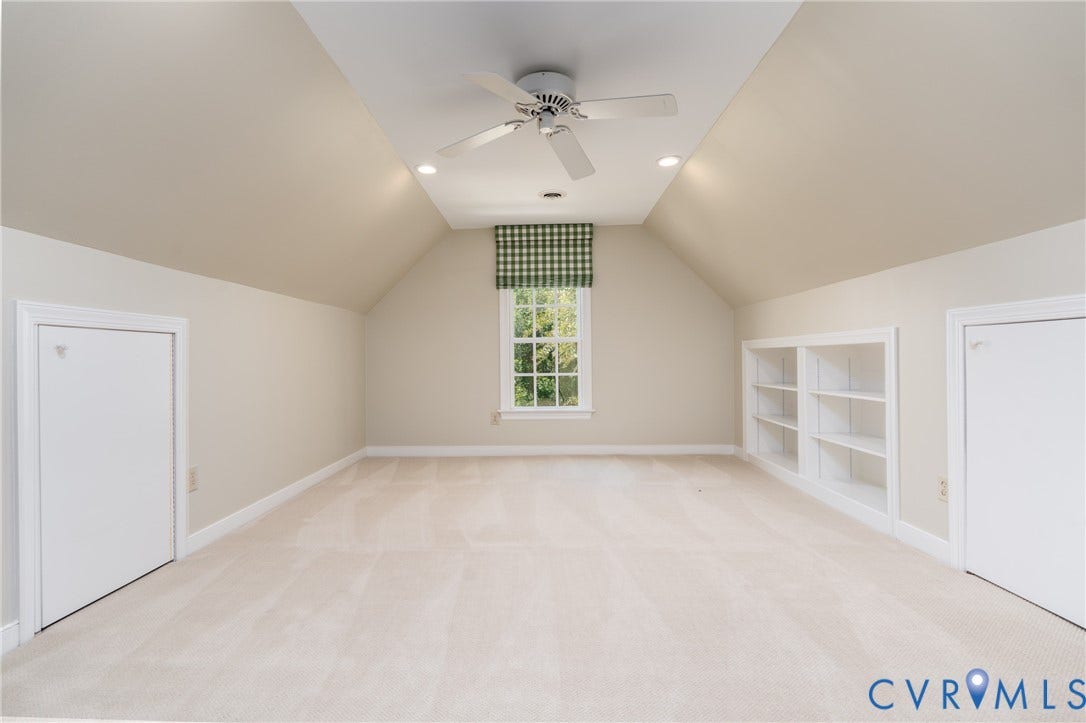 Carpeted room featuring a sloped ceiling, recessed lighting, and a ceiling fan