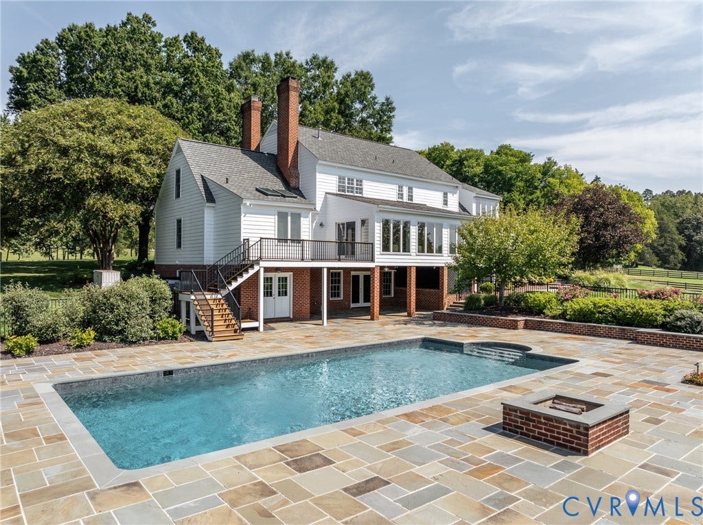 Spacious backyard with a rectangular swimming pool, integrated spa, and an outdoor fire pit