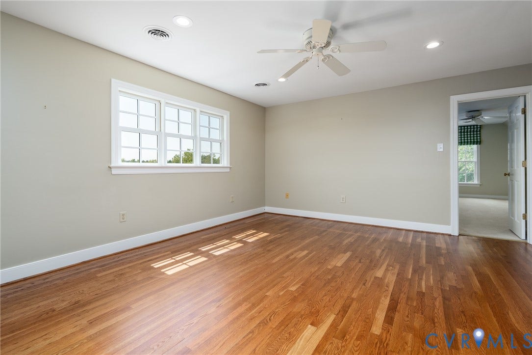 Hardwood-finish flooring, recessed lighting, ceiling fan, white trim, and a multi-pane window