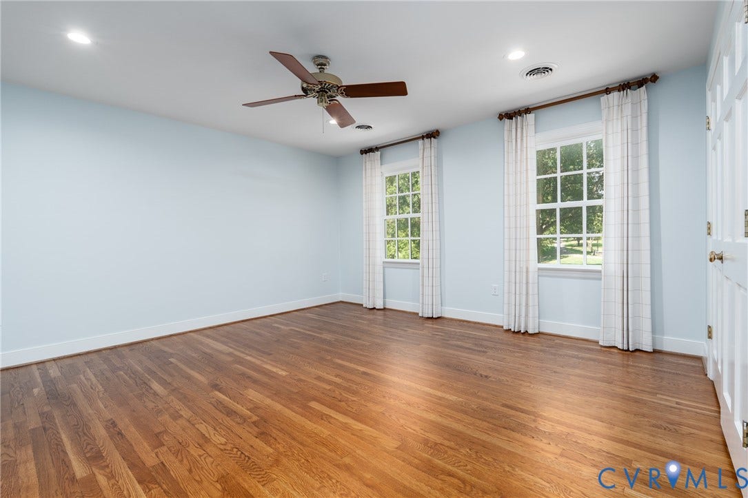 Hardwood flooring, recessed lighting, ceiling fan, and two multi-pane windows