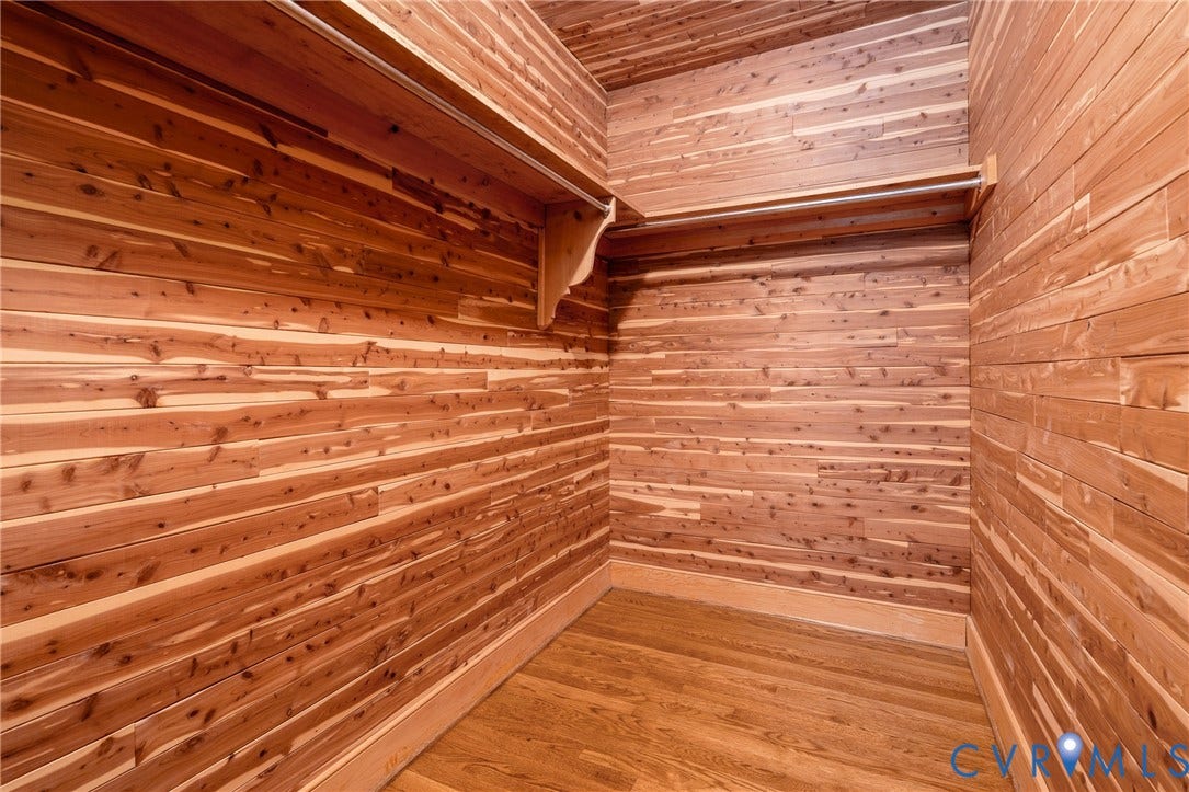 Cedar-lined closet featuring wood-finish flooring and integrated shelving