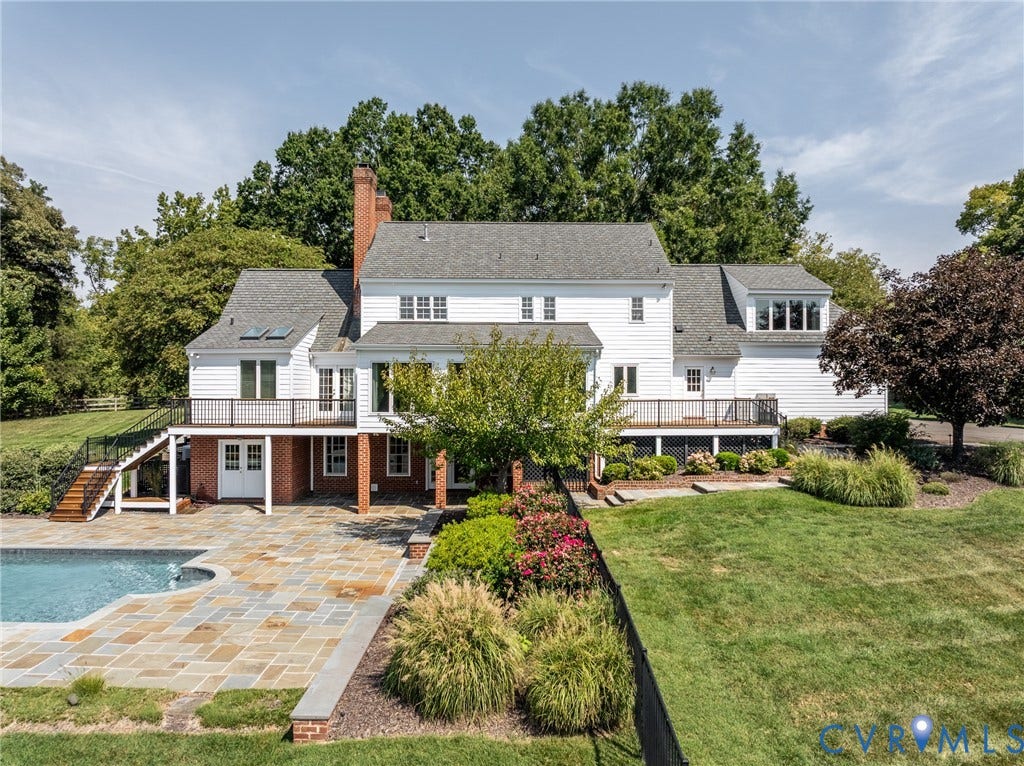 White siding exterior with multiple decks, an in-ground pool, and extensive landscaping