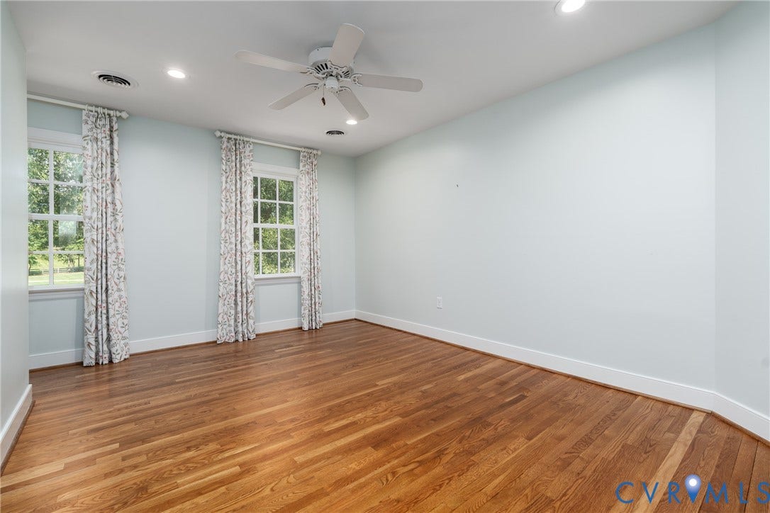 Hardwood flooring, recessed lighting, ceiling fan, and two windows
