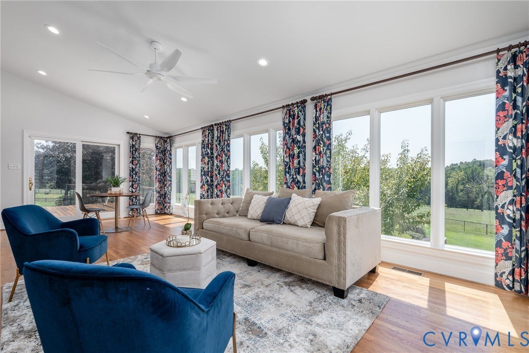 Vaulted ceiling with recessed lighting and a ceiling fan, wood-finish flooring, a wall of large windows, and sliding glass doors